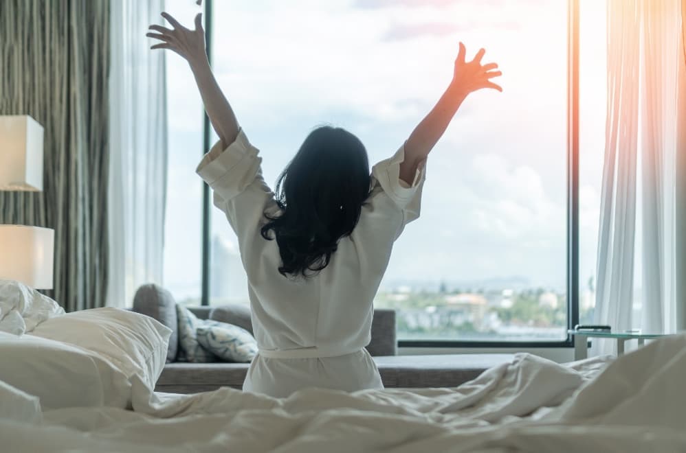 A woman relaxing with a beauty pillow and a pre-dyed European linen pad to support good sleep.