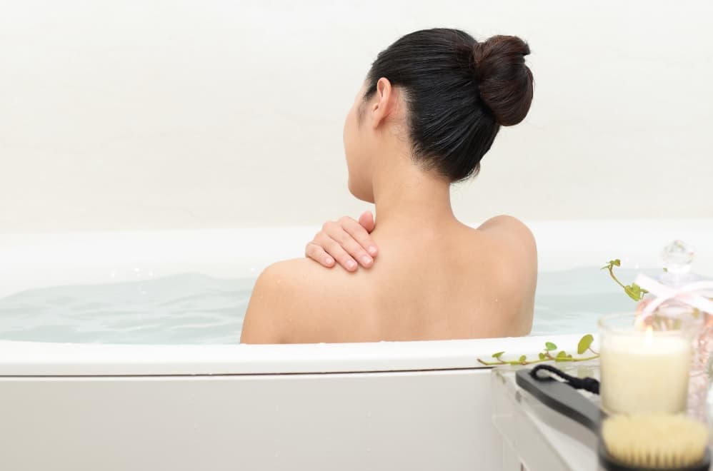 A woman who is relaxing in a bathtub.